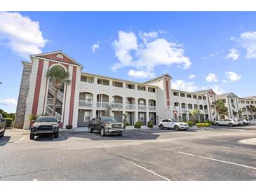 Spacious condominium building with ample parking and lovely landscaping under a beautiful blue sky at 4518 N Planatation Harbour Dr. # G-17, Little River, SC 29566