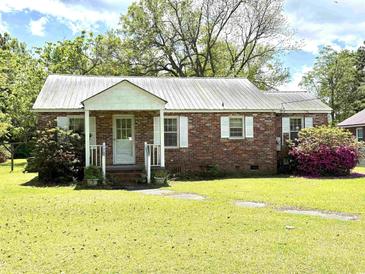 Charming single-story brick home with a metal roof and a well-maintained front yard at 701 Martin Luther King Dr., Andrews, SC 29510