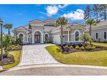 Stunning home featuring a tiled roof, well manicured landscaping, and paver driveway at 9407 Venezia Circle, Myrtle Beach, SC 29579