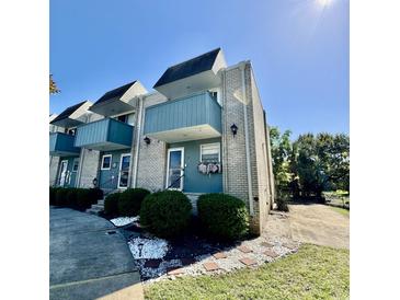 Attractive two-story condo showcasing a well-manicured lawn and blue exterior accents at 4701 N Kings Hwy. # 19, Myrtle Beach, SC 29579