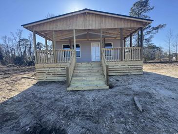 New construction home featuring a covered front porch with wooden decking and stairs at 491 N Green Sea Rd., Loris, SC 29569