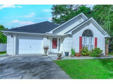 Charming single-story home with a white brick facade, red shutters, and a well-maintained lawn and a two car garage at 834 Holly Sands Blvd., Little River, SC 29566