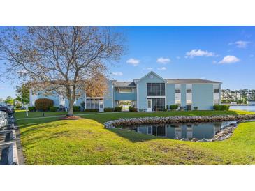 Beautiful condo building with lovely water views, screened-in porch, and lush landscaping at 8835 Chandler Dr. # E, Myrtle Beach, SC 29575