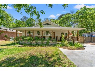 Charming home featuring a welcoming front porch with lovely plants and a well-maintained lawn at 1021 Myrtle Dr., Surfside Beach, SC 29575
