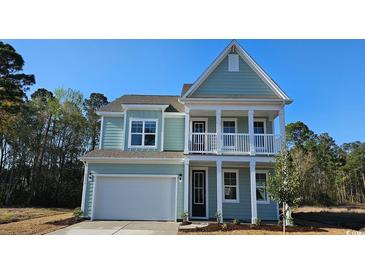 Charming two-story home features a covered porch, attached garage, and professionally landscaped yard at 305 Glacier Way, Conway, SC 29526