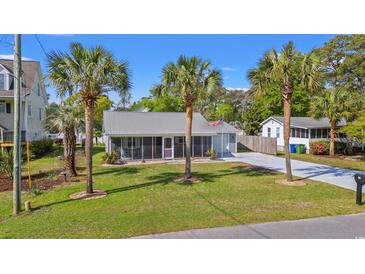 Charming single-story home featuring a metal roof, palm trees, and a well-maintained lawn at 319 Sparrow Dr., Surfside Beach, SC 29575