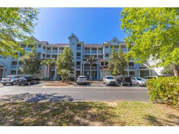 Low-rise condominium building with balconies, mature trees, and ample parking at 4560 Greenbriar Dr. # 306B, Little River, SC 29566