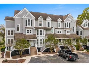 Well-maintained condo with gray siding, charming shutters, and inviting staircases leading to each entrance at 4999 Highway 17 Business # 302, Murrells Inlet, SC 29576