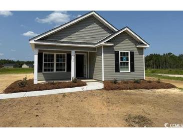 Charming single-story home featuring gray siding, a covered entryway, and well-manicured landscaping at 8050 Mill Pond Rd., Galivants Ferry, SC 29544