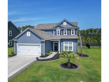 Charming two-story home featuring blue siding, a well-manicured lawn, and a two-car garage at 897 Wild Leaf Loop, Conway, SC 29526