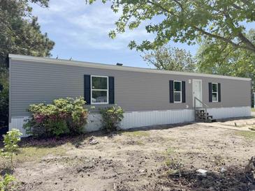 A charming gray single Gathering home with black shutters on a sunny day at 928 Baron Ln., North Myrtle Beach, SC 29582