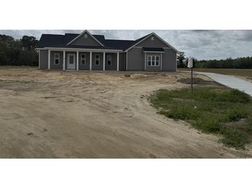 New home exterior with gray siding, black roof, white trim, and a covered front porch at Tbd 61 Persimmon Rd., Aynor, SC 29511