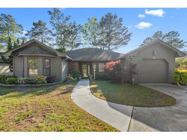 Charming single-story home with inviting walkway, well-manicured lawn and colorful landscaping at 111 Cedar Ridge Ln., Conway, SC 29526