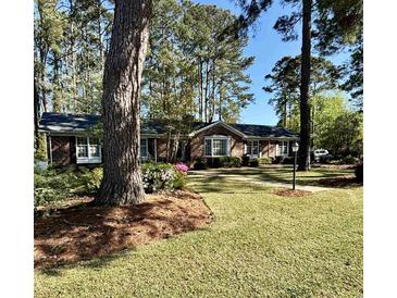 Traditional brick home with well-manicured lawn and mature trees provides great curb appeal at 116 Green Lake Dr., Myrtle Beach, SC 29572