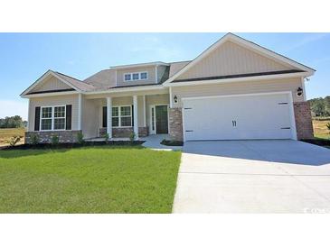 Beautiful single-story home with a two-car garage, manicured lawn, and attractive neutral-colored siding at 1233 Cypress Shoal Dr., Conway, SC 29526