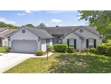 Charming single-story home features a well-maintained lawn and attached two-car garage at 1406 Snowy Egret Dr., Murrells Inlet, SC 29576