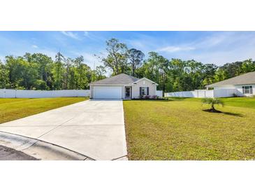 Charming single-story home with a well-manicured lawn, concrete driveway, and attached garage at 146 Brittmore Park Pl., Myrtle Beach, SC 29588