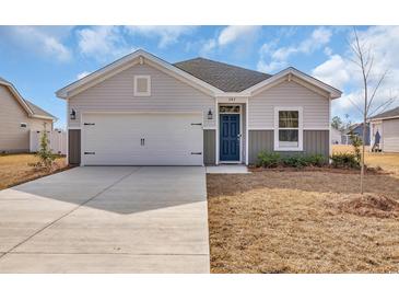 Charming single-story home featuring a two-car garage, blue front door, and manicured front lawn at 500 Honeyhill Loop, Conway, SC 29526