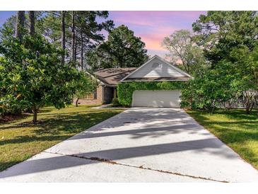 Charming single-story home with a well-maintained lawn and attached two-car garage with verdant foliage at 2934 Midiron Ct., Myrtle Beach, SC 29577