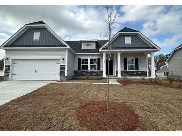 Charming single-Gathering home featuring a two-car garage, stone accents, and meticulously manicured lawn at 553 Honeyhill Loop, Conway, SC 29526
