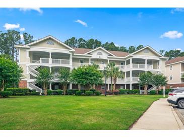 Beautiful condos with green lawns and white porches nestled among mature trees at 5825 Catalina Dr. # 1034, North Myrtle Beach, SC 29582