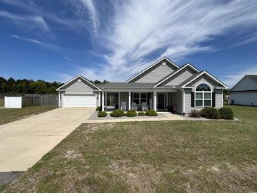 Charming single-story home with a manicured lawn and inviting front porch with rocking chairs at 7370 Johnson Shortcut Rd., Conway, SC 29527