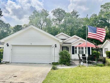 Charming single-story home with a well-manicured lawn and an inviting front patio area with seating at 1516 Saint George Ln., Myrtle Beach, SC 29588