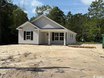 Charming single-story home with light gray siding, black shutters, and a welcoming front porch in a serene, wooded setting at 2991 Inheritance Rd., Conway, SC 29527