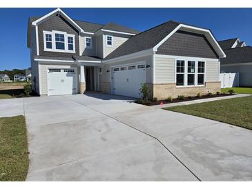 Charming two-story home with a three-car garage and manicured front lawn on a sunny day at 1004 Gold Dew Way, Myrtle Beach, SC 29579