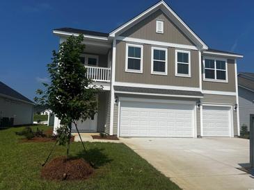 Charming two-story home boasts a two-car garage, complemented by a well-maintained lawn and blue skies at 1056 Laconic Dr., Myrtle Beach, SC 29588