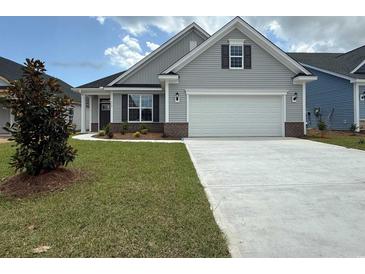 Charming single-story home with gray siding, landscaped yard, and a two-car garage at 1059 Laconic Dr., Myrtle Beach, SC 29588
