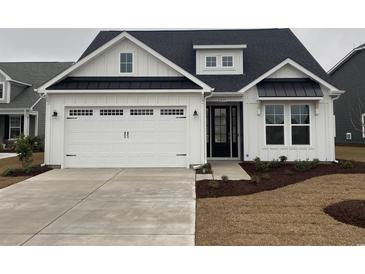 Charming single-Gathering home with a two-car garage, black accents, and professional landscaping at 1232 Needle Grass Loop, Myrtle Beach, SC 29579
