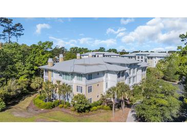 Aerial view of condo complex featuring manicured lawns and mature landscaping with palm trees at 1313 Villa Marbella Ct. # 4-102, Myrtle Beach, SC 29572