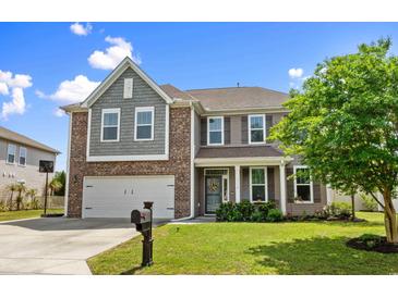 Charming two-story home featuring a manicured lawn, a two-car garage and a welcoming front porch at 3110 Bramble Glen Dr., Myrtle Beach, SC 29579