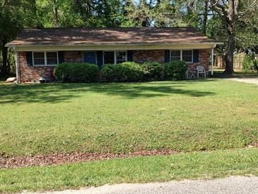 Charming single-story brick home with a well-manicured lawn and mature trees at 4011 Southern Cross Rd., Myrtle Beach, SC 29579