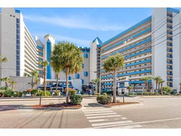 Stunning exterior view of a modern, multi-story resort with bright blue accents and lush landscaping at 7100 N Ocean Blvd. # 405, Myrtle Beach, SC 29572