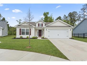 Charming single-story home with a well-manicured lawn and a two-car garage at 742 Woodside Dr., Conway, SC 29526