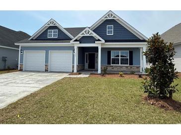 Charming single-Gathering home boasting blue siding, a two-car garage, and a well-manicured front yard at 1063 Laconic Dr., Myrtle Beach, SC 29588