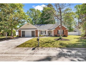 Charming single-story home featuring a well-manicured front lawn and attached two-car garage at 130 Ashton Circle, Myrtle Beach, SC 29588