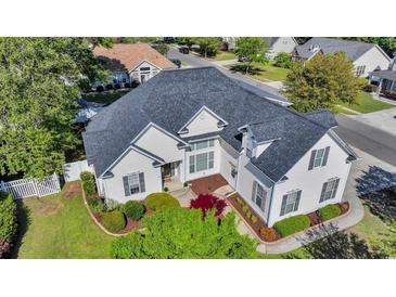 Well-maintained home with lush landscaping, white siding, black shutters, and a dark grey roof at 3300 Prioloe Dr., Myrtle Beach, SC 29588