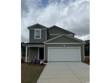 Two-story home with an attached garage and a well-manicured lawn at 135 Warner Crossing Way, Loris, SC 29569