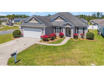 Charming single-story home with a manicured lawn, flower beds and an attached two-car garage at 1512 Virginia Pine Dr., Longs, SC 29568