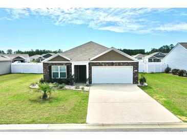Charming brick home with a well-manicured lawn and a two-car garage, perfect for suburban living at 203 Golden Bear Circle, Longs, SC 29568