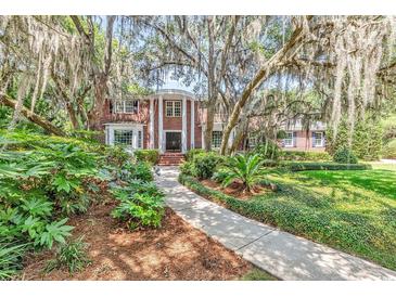 Charming brick home with mature trees and manicured landscaping along a winding walkway at 356 Chapman Loop, Pawleys Island, SC 29585
