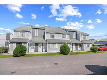 Attractive condo building featuring traditional architectural details and well-maintained landscaping at 3700 Golf Colony Lane # 18-G, Little River, SC 29566