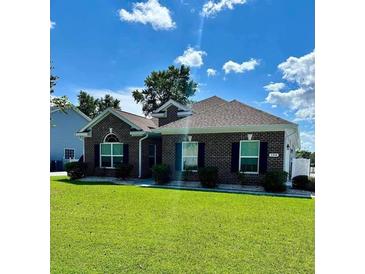 Well-maintained brick home featuring lush green lawn and manicured landscaping at 388 Carriage Lake Dr., Little River, SC 29566