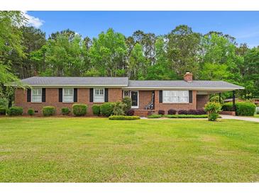 Charming brick ranch home featuring a well-maintained lawn and mature trees at 5033 Brantwood Dr., Mullins, SC 29574