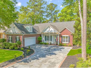 Charming brick home with a well-manicured lawn, a circular driveway, and mature trees, creating an inviting curb appeal at 5647 S Blackmoor Dr., Murrells Inlet, SC 29576