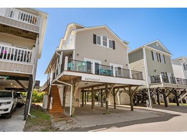 Beautiful elevated beach home with a balcony, parking, and a clear blue sky above at 6001-1205 S Kings Hwy., Myrtle Beach, SC 29575