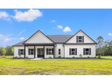 Charming single-story home featuring black trim, white siding, and a well-maintained lawn at 7103 Louisville Rd., Aynor, SC 29511